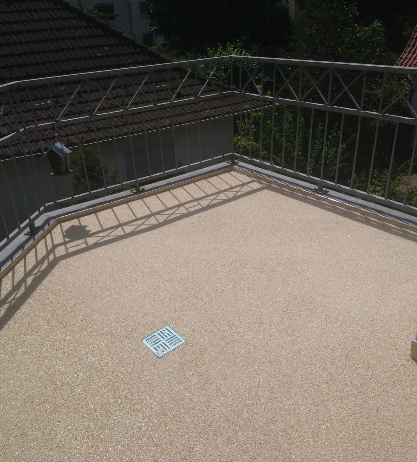 Steinteppich auf Balkon in warmem Beige mit Bodenablauf