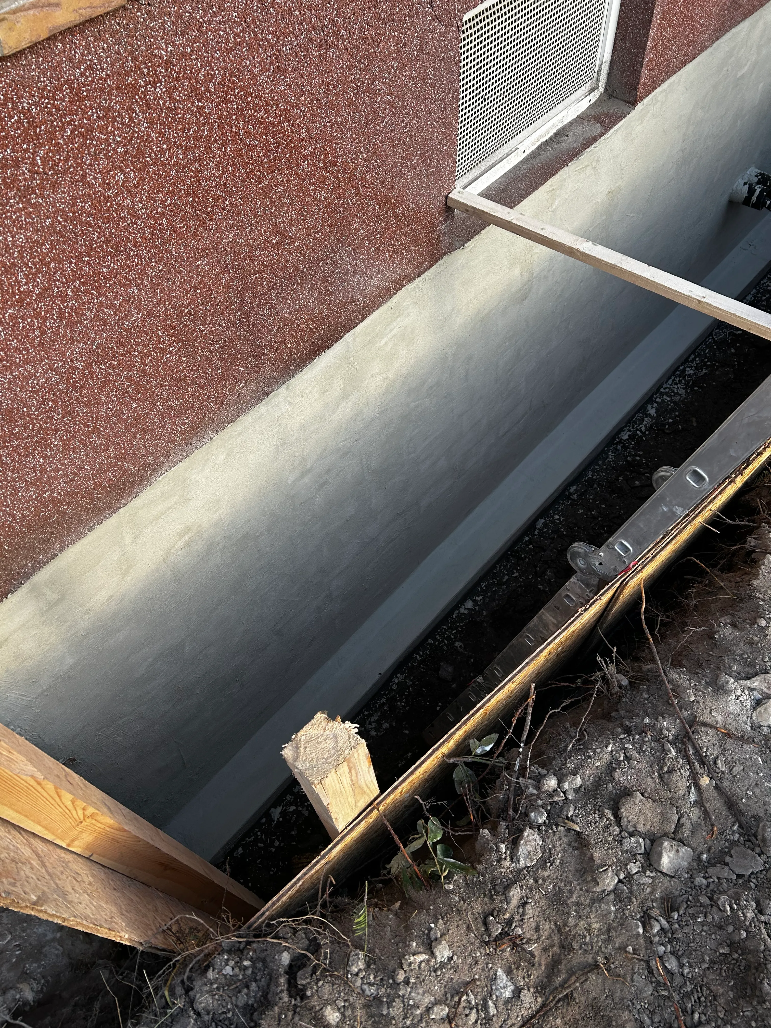 Fertige zweilagige Dichtschlämme-Abdichtung an der Kellerwand